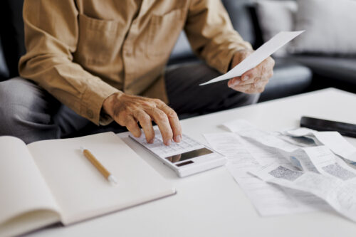 Close up of Senior man checking bills at home