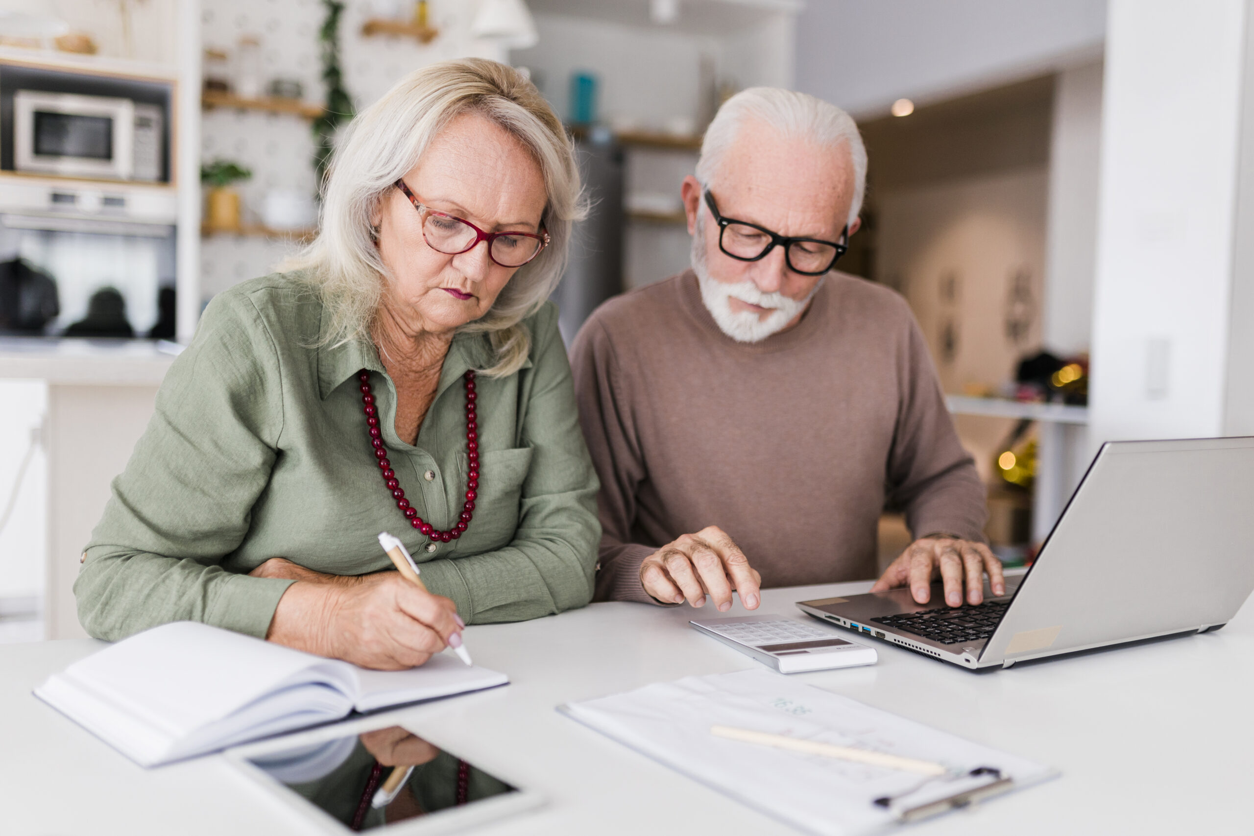 Senior couple using laptop while planning their home budget,